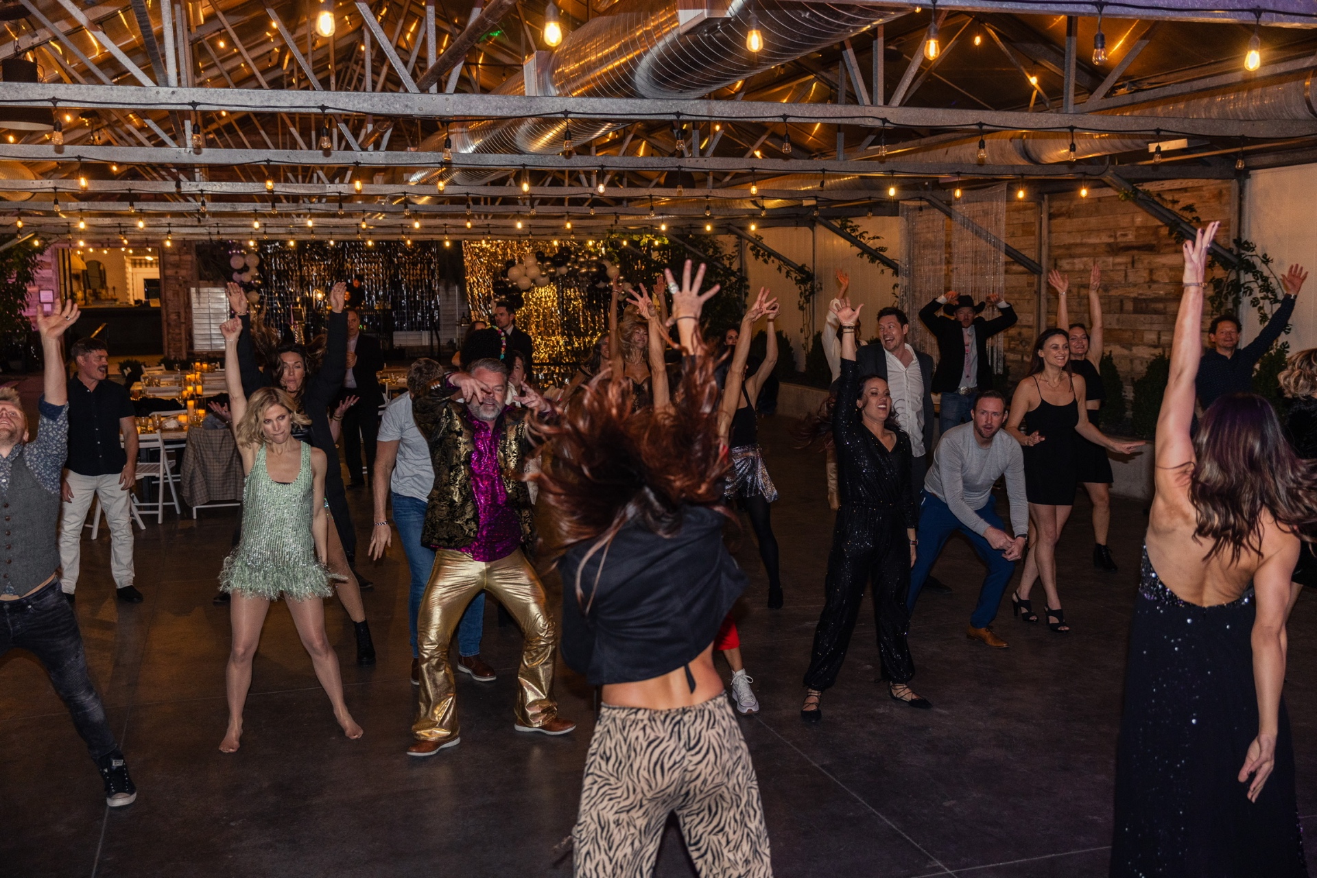 A room of people dancing with arms in the air